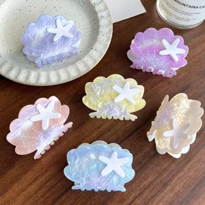 Close-up detail of cute shell hair claw clips with starfish decor in various pastel colors.