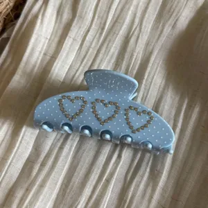 Vista dettagliata della pinza per capelli con cuori in strass e pois azzurri per tutti i giorni.