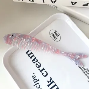 Detallada vista cercana del hermoso peine de acetato con diseño de forma de pez.