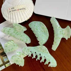 Detailopname van groen geruite haarspelden met verschillende vormen en glanzende harsafwerking.