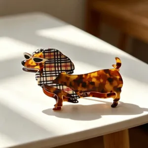 Detailed close-up of cute dachshund hair claw clip with tortoise shell pattern and check scarf.