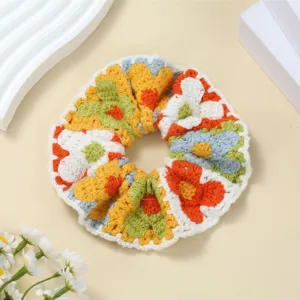 Handgemaakte gehaakte bloemvormige haarscrunchie detailweergave met kleurrijk gebreid patroon.