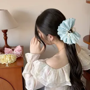Detailed view of sweet lace ruffle hair claw clip with cute ribbon bow design, worn neatly.