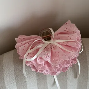 Pink lace hair claw detail with cute white ribbon bow, sweet hair accessory close up.