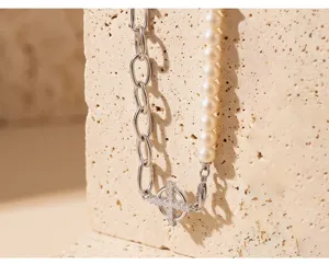 Detail view of the stylish cross chain and pearl spliced necklace with sparkling pendant.