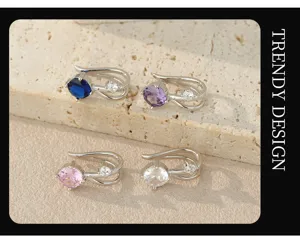 Primo piano di orecchini cuff in argento senza piercing con zirconi colorati, dettaglio.