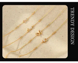 Λεπτομέρεια επιχρυσωμένου πολυεπίπεδου βραχιόλι με χαριτωμένα φυλαχτά και ζιργκόν.