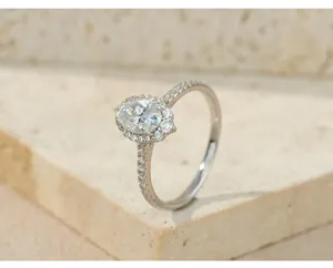 Primer plano detallado de un elegante anillo de halo de moissanita ovalada en piedra.