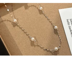 Detail view of the silver-plated pearl chain necklace, highlighting delicate links and pearls.
