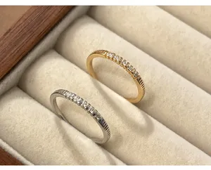 Primer plano de anillos pavé delicados en oro y plata presentados en un elegante joyero.