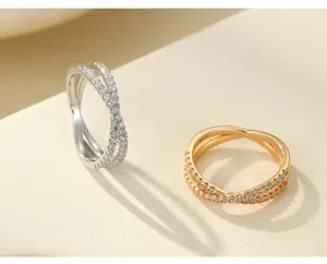 Gros plan sur des bagues croisées en argent sterling S925 avec strass en argent et or.
