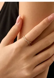 Gros plan d'un anneau croisé pavé à double bande en argent sterling plaqué or 14k.