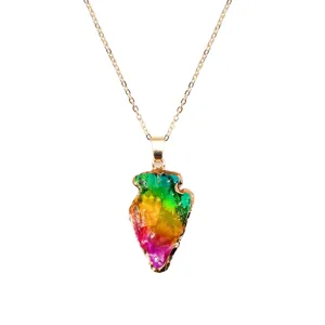Rainbow crystal arrowhead pendant necklace detail, vibrant natural stone with gold chain jewelry.