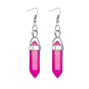 Close-up detail of vibrant pink hexagonal crystal bullet earrings with silver hooks.