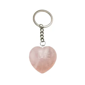 Llavero de cuarzo rosa natural en forma de corazón con anillo metálico y piedra pulida.