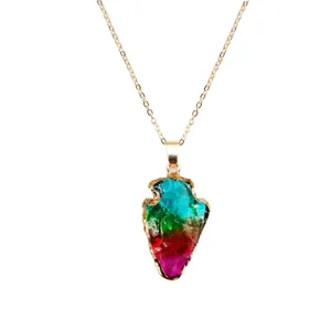 Colorful arrowhead crystal pendant necklace detail close-up showing vibrant gradient stones.