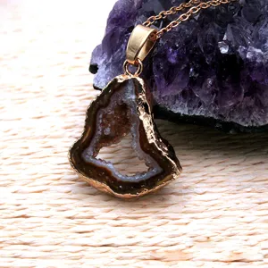 Natural agate geode slice pendant detail with gold electroplated bezel and fine chain display.