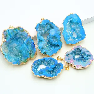 Nahaufnahme von naturblauen Achat-Geoden-Kristallanhängern mit Goldrand für DIY-Schmuckherstellung.