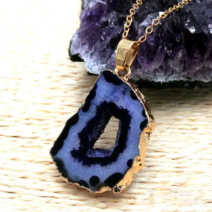 Natural agate geode pendant necklace with gold plated edge and purple crystal cluster detail.