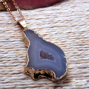 Natural agate geode pendant detail showing gold-plated rim and textured gemstone surface.