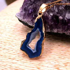 Blue agate geode slice pendant with gold electroplated edge and delicate chain, detail view.
