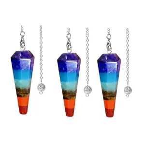 Detail view of colorful crystal chakra hexagonal column pendulum pendant with silver chain.