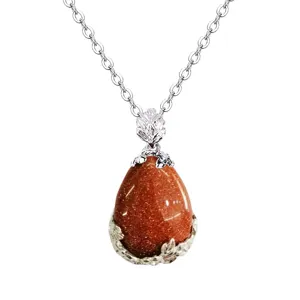 Collana con ciondolo in pietra di rena marrone a goccia con catena floreale argentata.