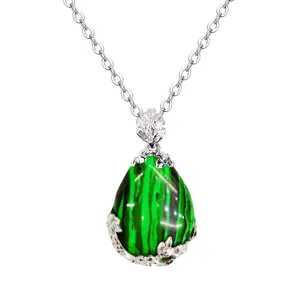 Primo piano dettagliato di una collana con ciondolo in pietra verde e montatura a foglia.