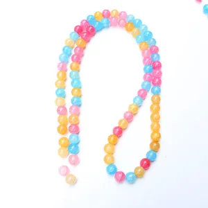 Scatto dettagliato di fili di perle di vetro craquelé colorate, ideali per accessori di gioielleria.