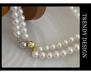 Close-up of double pearl necklace detail, showcasing smooth luster and magnetic clasps.