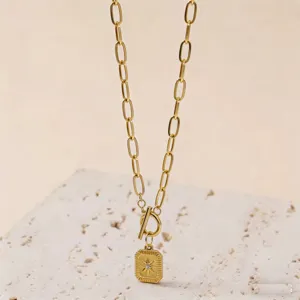 Nahaufnahme der goldenen Achtstern-Viereck-Halskette mit T-Verschluss und Steindetail.