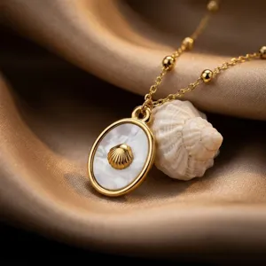 Squisita collana con ciondolo a conchiglia con madreperla e delicate perle d'oro.