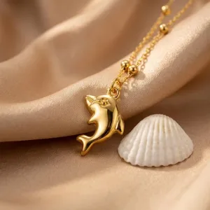 Dettaglio squisito della collana con ciondolo delfino d'oro, stile marino chic.