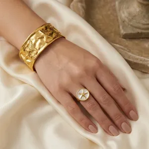 Set bracciale rigido e anello dorati stile marino con motivi di stella marina e cavalluccio.