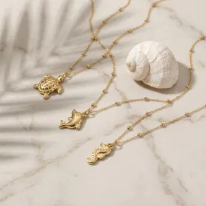 Elegante collana dorata stile marino con ciondoli tartaruga, delfino e cavalluccio per donne.