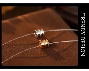 Detailed close-up view of elegant double-color barrel pendant necklace on transparent line.