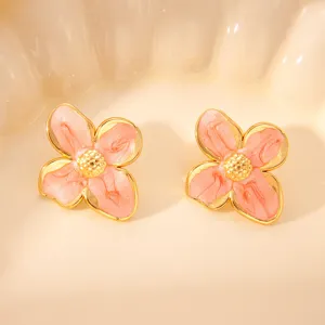 Orecchini vintage in smalto rosa con fiore a quattro petali, elegante design con bordo dorato.