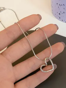 Collana minimalista con ciondolo a cuore vuoto argento, catena a serpente per uso quotidiano.