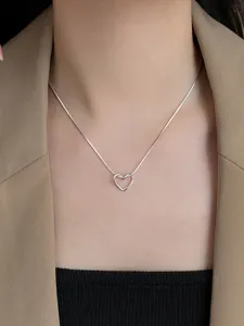 Primo piano della collana con ciondolo a cuore annodato e dettagli raffinati della catena a serpente.