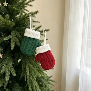 Nahaufnahme von weihnachtlichen Mini-Strickhandschuh-Bestecktaschen am festlichen Weihnachtsbaum.