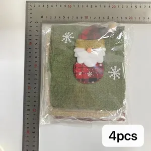Detalle de primer plano de funda de botella de vino navideña de lino con muñeco de Papá Noël.