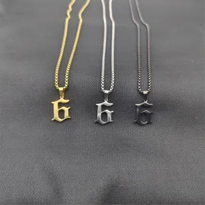 Collier pendentif chiffre 6 gothique en acier inoxydable en gros plan avec chaînes or, argent et noir.