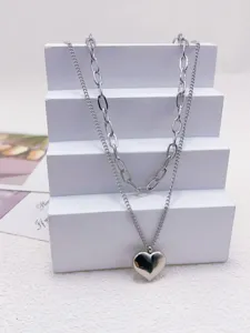Vista dettagliata di una collana doppia in acciaio inossidabile argentato con cuore.