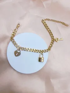 Goldfarbenes Edelstahlkettenarmband mit Herzschloss, Liebesschloss und Schlüsseln, Detailansicht.