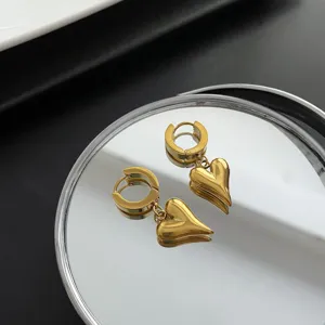 Goldene Titan Stahl Herz Anhänger Ohrringe, schicker minimalistischer Schmuck Detail.