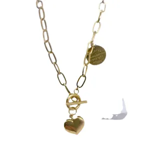 Collana con catena grossa dorata e ciondolo a cuore con chiusura T per donna moda