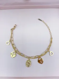 Detailansicht des goldenen Bettelarmbands mit Herzschlössern und Kreuzanhänger im Nah.