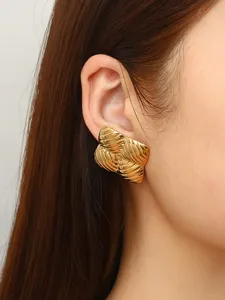 Goldene geometrische Muschel Ohrringe detaillierte Nahaufnahme mit strukturiertem Metalldesign.