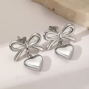 Gros plan de boucles d'oreilles nœud cœur argentées, design élégant pour femmes tous les jours