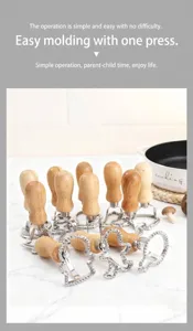 Dettaglio di stampini per biscotti natalizi in acciaio con manici in legno.